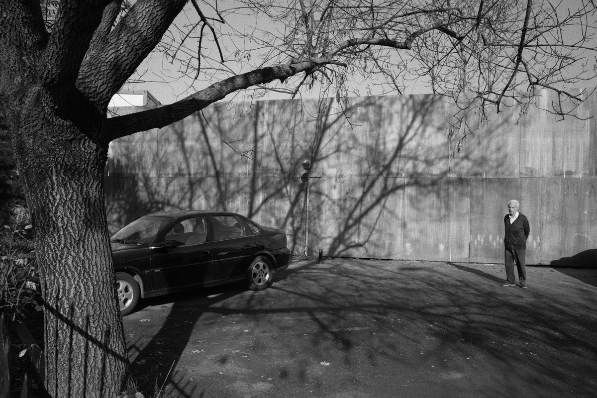 Tree, car, and a man waiting. Levent.
